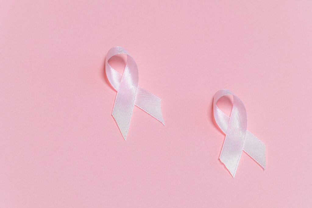 Pink ribbons symbolizing breast cancer awareness on a pink background.